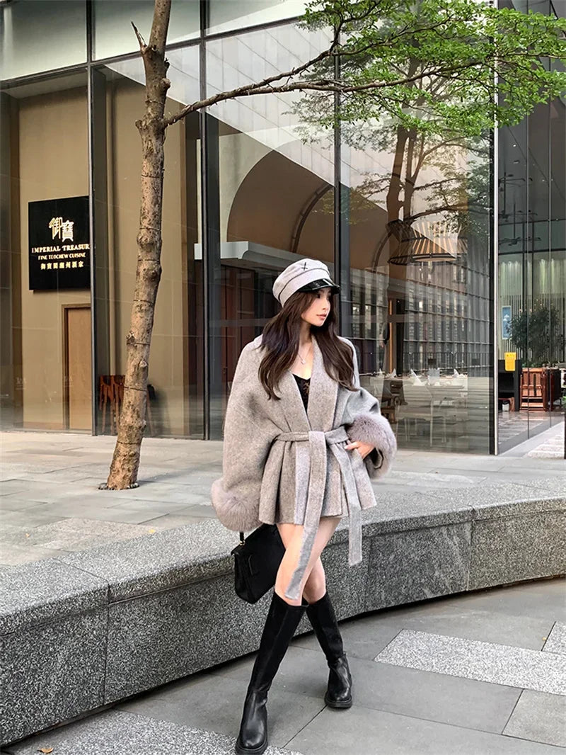 Grauer Wollmantel mit Krawatten-Taillenkollektion für Damen im Herbst und Winter 2024, neuer langärmeliger, lockerer High-End-Cape-Mantel, mittellanges Oberteil.