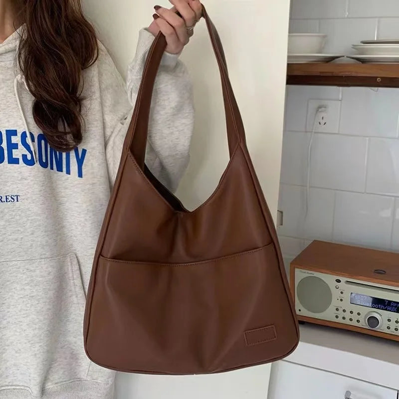 Large capacity tote bag, new black leather simple casual commuting women's bag, fashionable and versatile single shoulder bag.