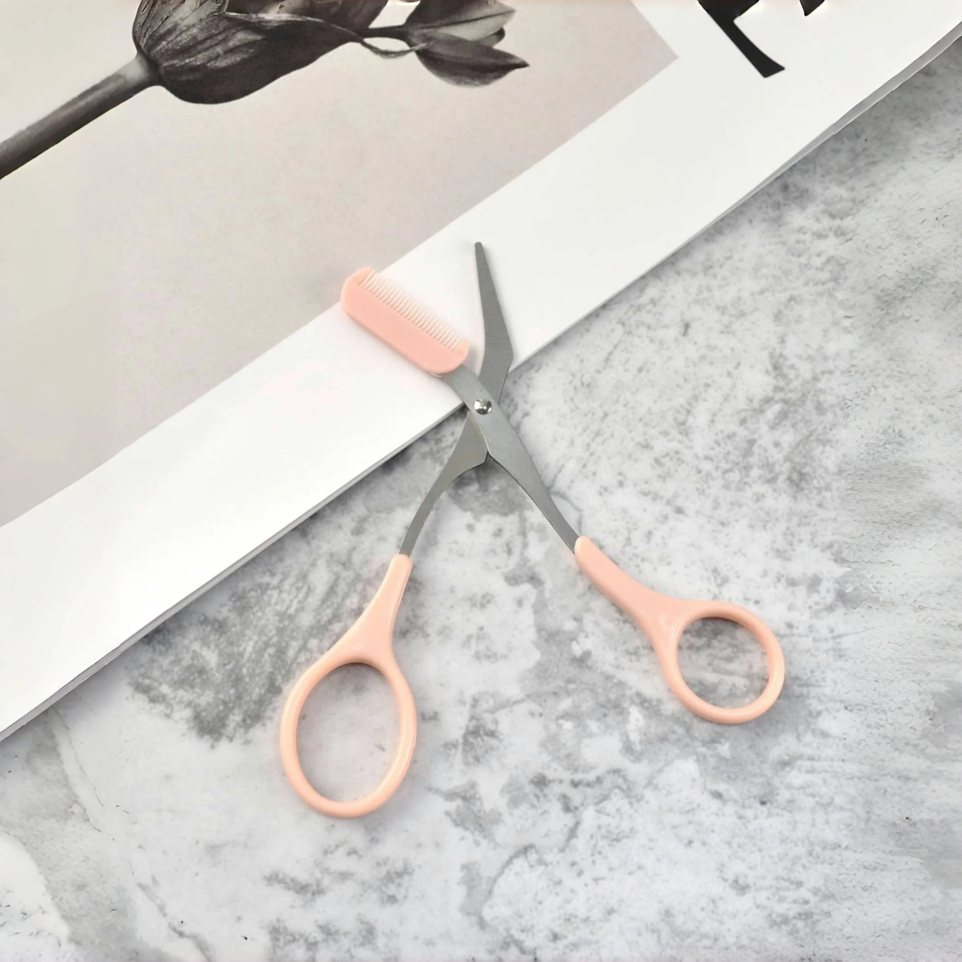 Pink eyebrow trimming scissors with built-in comb - stainless steel, precise grooming tool, creating perfect eyebrows.