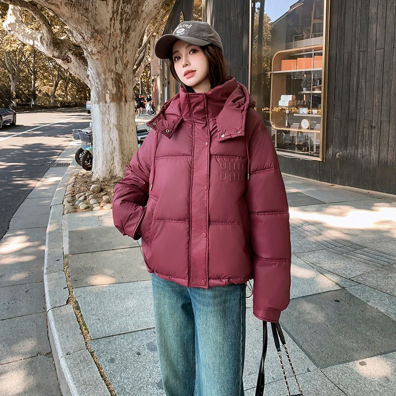 2024 Winter Neue frauen Unten Baumwolle Gefütterte Jacken Stilvolle Mit Kapuze Einfarbig Casual Verdicken Warme Lose anliegende kurze Mäntel.