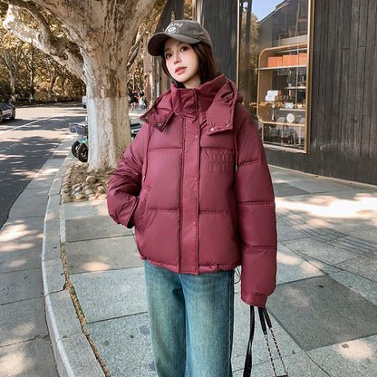 2024 Winter Neue frauen Unten Baumwolle Gefütterte Jacken Stilvolle Mit Kapuze Einfarbig Casual Verdicken Warme Lose anliegende kurze Mäntel.