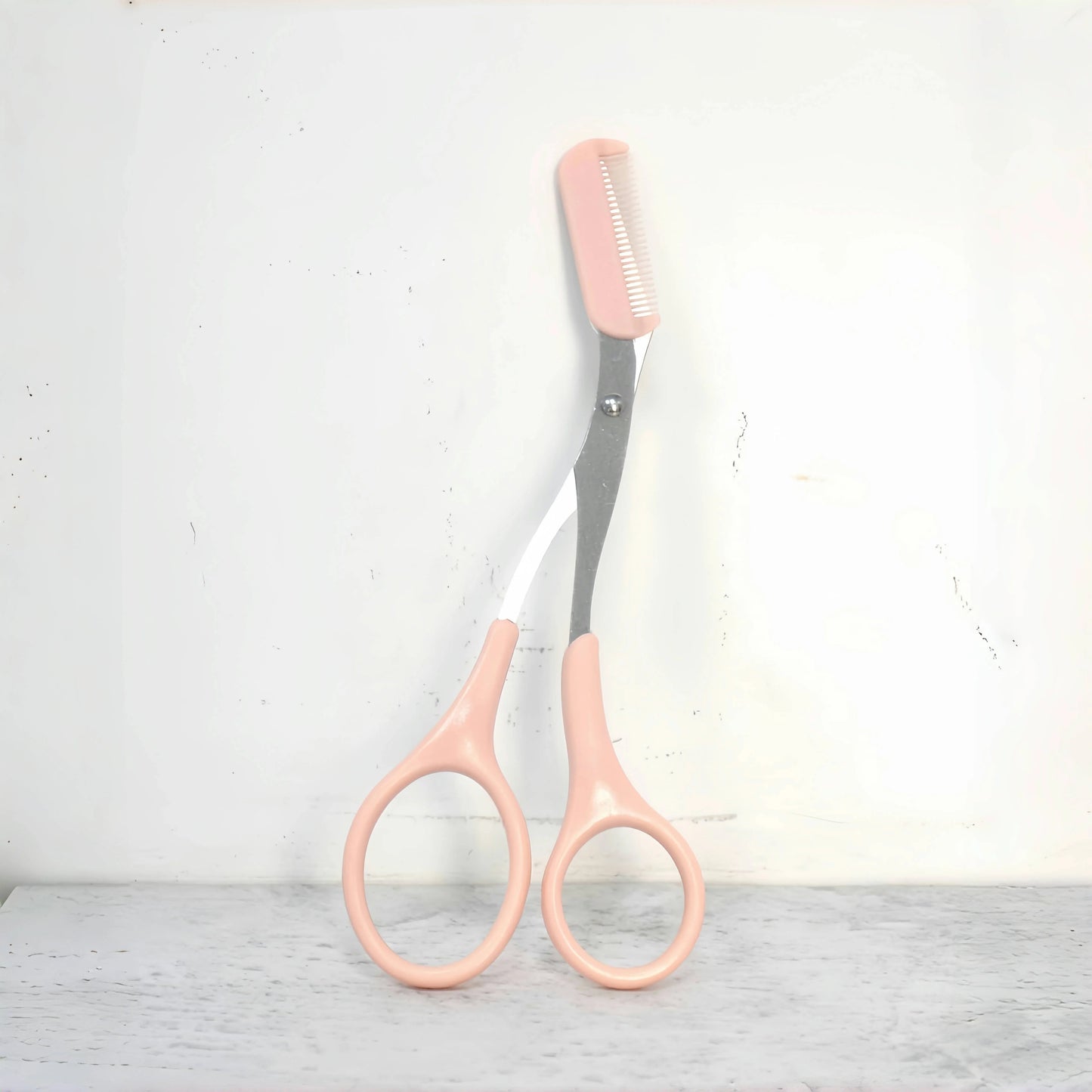 Pink eyebrow trimming scissors with built-in comb - stainless steel, precise grooming tool, creating perfect eyebrows.