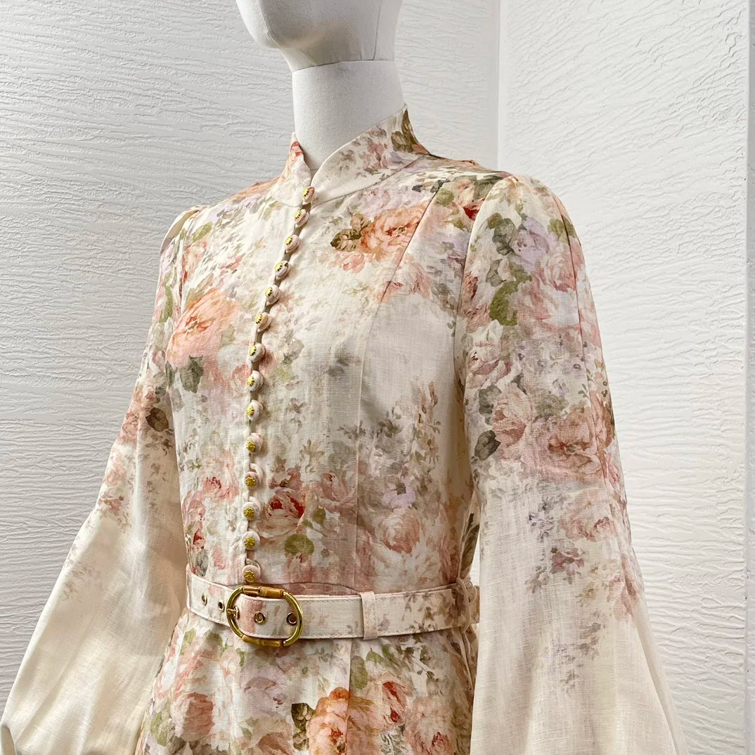 Schwarzes Leinen-Midikleid mit Rokoko-Blumendruck, langen Ärmeln und hoher Taille.