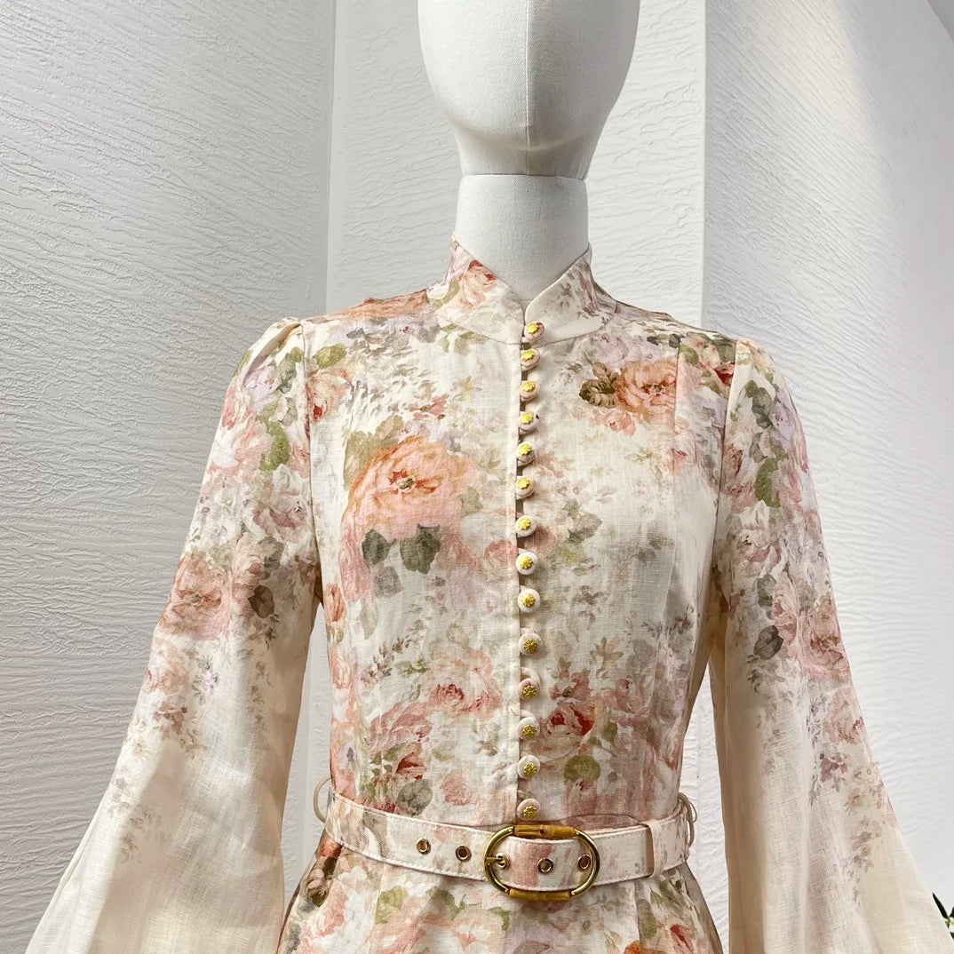 Schwarzes Leinen-Midikleid mit Rokoko-Blumendruck, langen Ärmeln und hoher Taille.